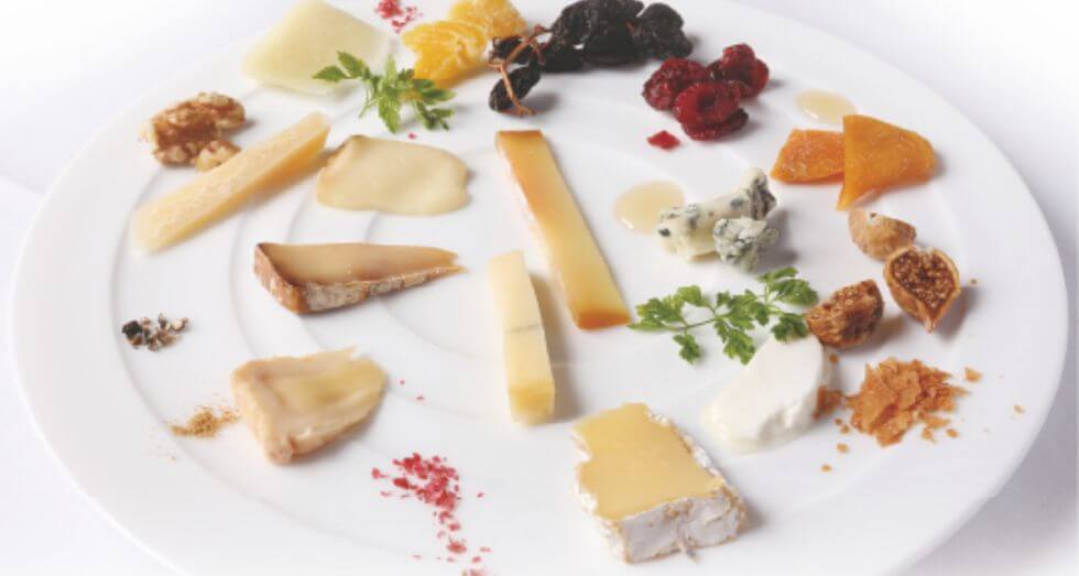 10種類のチーズが丸くて白い皿に並べられている。